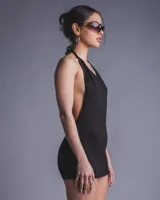 Minivestido negro con espalda descubierta, cuello halter y estampado trasero con la frase "BabyGirl" en glitter.