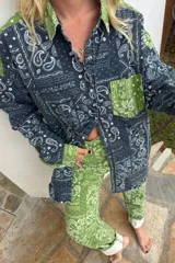 Camisa oversize de algodón con estampado bandana en tonos azul y verde. Diseño de bloques de color, cuello clásico, puños abotonados y bolsillo delantero en contraste.