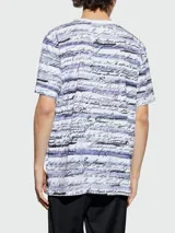 Remera de algodón blanca con estampado de texto en color lila y negro.