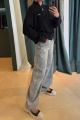 Sweater de punto acanalado con cuello alto y cierre frontal parcial. Presenta un diseño tricolor en bloques con cuerpo color crema, cuello y puños azul marino, y detalles en rojo en las mangas. Incluye una pequeña etiqueta con logo en el pecho.