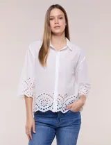 Camisa de calce holgado color blanco, confeccionada en tejido liviano de algodón, con cuello camisero clásico, mangas tres cuartos y terminación en puños y ruedo con diseño de bordado broderie calado y festoneado.