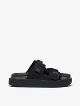 Sandalias negras con tiras de cuero y suela gruesa.