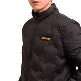 Chaqueta acolchada negra con cierre frontal completo, cuello alto y parche de silicona con el logotipo de la marca en el pecho. Presenta diseño con costuras selladas, bolsillos laterales y ribetes elásticos en puños y dobladillo.