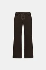 Jeans de tiro alto color marrón oscuro, con pernera recta y detalle de cordones cruzados en la parte delantera central. Presenta costuras contrastantes en color claro.