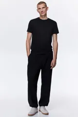 Remera H&M de corte ajustado, confeccionada en punto de algodón liviano, con cuello redondo ribeteado y bajo recto.
