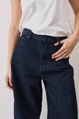Jeans de denim azul oscuro con corte barrel y diseño amplio en las piernas.