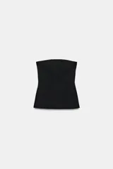 Top negro strapless de tejido elástico, con escote recto y aberturas laterales en el bajo.