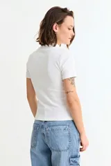 Remera de manga corta con cuello media polera, confeccionada en tejido acanalado al cuerpo.