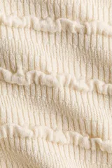 Top de punto color crema con textura acanalada y pequeños volados horizontales, cuello redondo y mangas cortas.