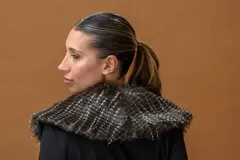 Saco largo negro de viscosa con caída fluida, manga larga y cuello de piel sintética desmontable.