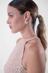 Vestido largo con cuello halter enteramente cubierto de lentejuelas, que combina un cuerpo superior en tono rosado y una falda larga en color negro.