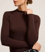 Blusa negra de rib de viscosa sostenible, con cuello alto y mangas largas.