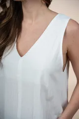Vestido largo blanco de algodón, sin mangas, con escote en V y diseño amplio y liviano.