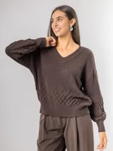 Sweater de punto color marrón con escote en V, mangas largas levemente abullonadas y diseño texturizado con patrón de escamas en la parte inferior y mangas.