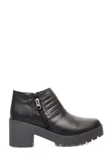 Botín negro de cuero con cierre metálico lateral, costuras decorativas y suela track con plataforma.