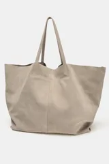 Bolso tipo maxi shopper confeccionado en serraje, con diseño minimalista y doble asa de hombro. Cuenta con un compartimento principal amplio y un bolsillo interior con cierre.