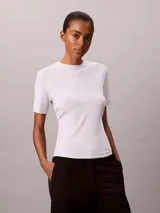 Remera Calvin Klein de manga corta y cuello redondo, color blanco, confeccionada en algodón pima. Presenta costuras verticales en el frente y un sutil logo script de la marca bordado en el pecho.