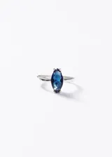 Anillo de plata 925 con piedra zirconia central de corte marquesa en color azul profundo.