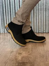 Botín marrón de cuero con elásticos laterales, suela de goma color caramelo y puntera reforzada.