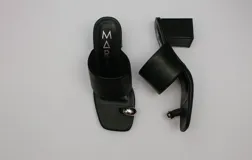 Sandalias de cuero color bronce con taco cuadrado y tira ancha sobre el empeine. Presentan un aro metálico plateado que separa el dedo gordo del resto.