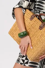 Pulsera rígida de resina translúcida en tonos verdes con efecto marmoleado.