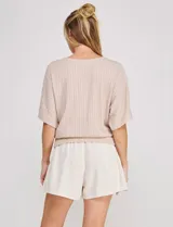 Blusa Allie Rose de punto liviano color beige, con trama texturada en relieve de efecto gofrado, silueta relajada, escote redondo amplio, mangas cortas holgadas de corte mariposa y ruedo con pretina ancha.