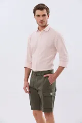 Bermuda cargo color azul marino, de gabardina con bolsillos laterales con solapa en las piernas y presillas para cinturón. Incluye cinturón de lona trenzada oscura con detalles en cuero sintético y hebilla metálica.