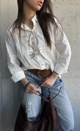 Camisa blanca de manga larga con detalles de broderie y calados en el frente y las mangas.