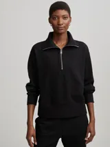 Sweater deportivo negro con cierre de medio largo en el cuello y textura acanalada.