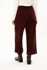 Pantalón de corte recto y tiro alto en color bordó, con diseño de pinzas en la cintura, bolsillos laterales y ruedo con dobladillo ancho.