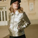 Campera de cuero sintético metalizado en color plateado, con cuello clásico, cierre frontal completo y bolsillos laterales.