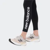 Calza deportiva de tiro alto color negro, con logo de la marca en el muslo y estampado vertical en contraste en la parte inferior de la pierna. Confeccionada en tejido elástico con tecnología de secado rápido.