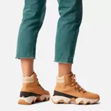 Botas de caña media color marrón claro, con cordones y suela de goma con diseño ondulado en color blanco y marrón.