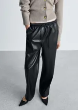 Pantalon de efecto piel con cintura elástica y lazo ajustable. Presenta un diseño de corte recto tipo jogger con bolsillos laterales.