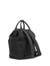 Mochila Hush Puppies de color negro, diseñada con múltiples bolsillos frontales con cierre, asas superiores y el logotipo de la marca impreso en la parte inferior.