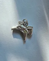 Dije colgante con forma de cabeza de caballo, realizado en metal plateado con acabado texturizado.