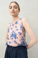 Top sin mangas de silueta recta y caída liviana, color rosado con estampado floral abstracto en azul. Presenta escote redondo.