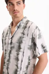 Camisa de manga corta con estampado tie-dye en tonos verdes y blancos, cuello cubano y cierre frontal con botones.