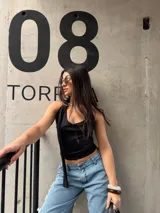 Top negro de jersey lycra, con escote redondo y detalle de tiras colgantes en el hombro.
