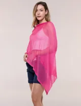 Poncho liviano de tejido de punto fino calado, color blanco, con silueta asimétrica envolvente, escote bote drapeado y mangas integradas estilo capa.