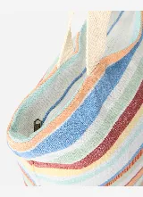 Bolso de mano tipo tote bag de Rip Curl, modelo Oceanic Interest, con diseño de rayas horizontales multicolor y asas dobles de tela color beige.