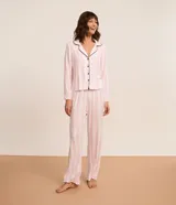 Conjunto de pijama largo de la marca Lov, confeccionado en viscosa con diseño de rayas verticales en tonos rosado y blanco. Consta de una camisa de manga larga con cuello solapa, cierre frontal de botones y ribetes negros en contraste, y un pantalón largo con cintura elástica.