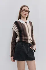 Minifalda de jean negra con silueta recta, tiro medio y bolsillos funcionales delanteros y traseros.