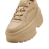 Championes Puma modelo Karmen X-tra, color beige, con diseño de plataforma alta y suela dentada. Presentan una silueta robusta con detalles de costuras y el logo de la marca en el lateral y el talón.