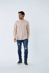 Camisa de hombre con cuello mao y mangas largas, confeccionada en tejido de algodón con textura tipo lino. Presenta cierre frontal con botones y un pequeño logo bordado en el pecho.