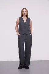 Pantalón de vestir gris oscuro con finas rayas verticales blancas, corte palazzo y bolsillos laterales.