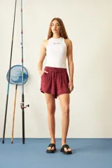 Short color borgoña de viscosa con cintura elástica ajustable con cordón, bolsillos laterales y corte holgado.