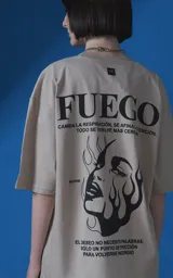 Remera de manga corta y cuello redondo con calce oversize, color beige con estampa gráfica en negro que incluye texto y un rostro femenino estilizado con llamas.