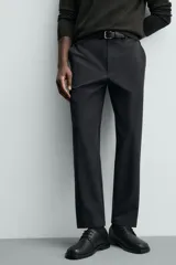 Pantalón de corte regular fit, color negro, confeccionado en tejido elástico. Presenta cintura elástica, cierre frontal con cremallera y botón, bolsillos laterales y bolsillos traseros de vivo.