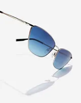 Lentes de sol Hawkers unisex, modelo Fresh, con montura plateada de metal y lentes degradadas de azul a verde.